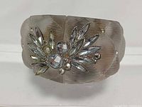 Front view of cuff showing quilted lucite texture and rhinestone floral cluster