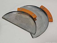 Two chrome half-moon crumb trays nested together, showing Bakelite handles and star screws