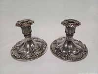 Front view showing both candle holders with ornate bases and columns