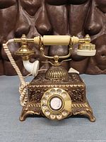 Front view of brass filigree rotary phone with cameo dial