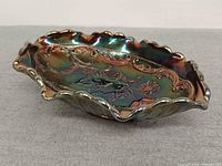 Angled view of iridescent Fenton poppy dish showing ruffled rim and interior floral pattern