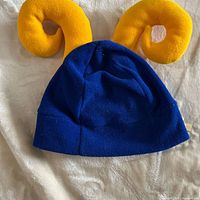 Front view of blue beanie with yellow plush horns