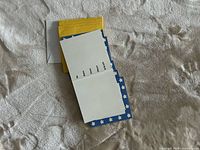 Stack of RSVP cards with blue border, interior view, yellow and white envelopes visible