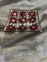 Angled view of square glass dish showing poinsettia and gold accents