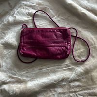 Front view of magenta leather pouch purse with strap