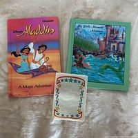 Front covers of Aladdin and Little Mermaid storybooks with star-border card