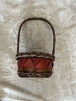 Natural and russet red woven basket with braided rim and handle