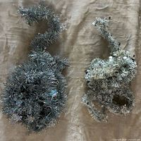 All three silver tinsel garlands coiled on surface