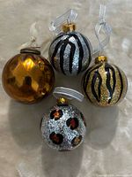 Front view of all four animal print ornaments showing colors and patterns