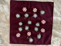 Peppermint LED tea lights and silver tinsel ball ornaments displayed on cloth