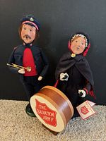 Front view of male and female Salvation Army Carolers with kettle drum