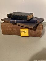 Stack of four vintage books showing relative sizes and bindings