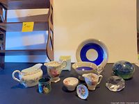 Group shot showing all items including shelf, paperweights, porcelain pieces