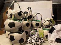 Multiple soccer-ball treat baskets stacked together with handles visible