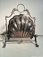 Front view of closed shell-form biscuit server on stand