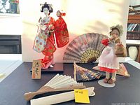 Overview of both dolls, fans, plaque and basket