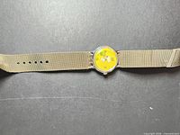 Front view of Snoopy tennis wristwatch with beige nylon strap
