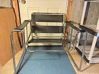 Front view of chrome tubular lounge chair with black straps