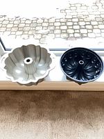 Silver fluted Bundt pan and black swirl Bundt pan side by side