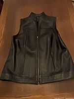 Front view of black leather vest showing zipper and collar