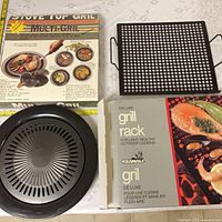 Overall lot showing boxed stove-top grill, loose grill parts, and boxed Keanall grill rack