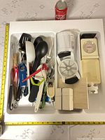 Overall view of utensils in drawer tray with scale and grater