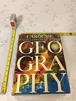 Front of hardcover book with tape measure for scale