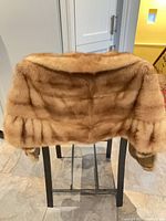 Rear view of brown mink fur stole draped over chair