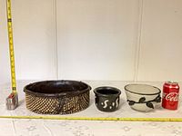 All three pots side by side with measuring tape and soda can for scale