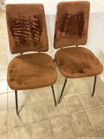 Front view of two brown faux fur chairs