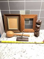 overview of all items: two frames, maraca, metal figure sculpture, carved wood sculpture