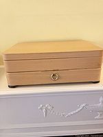 Closed light wood chest on dresser top