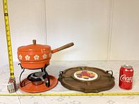 Fondue pot set, charcuterie board, Coca-Cola can and measuring tape for scale