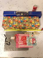 Top view of gift box, blue sleeve wrap, three bags, tape measure and soda can for scale