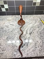 Full view of metal sconce showing serpentine arm and cone shade