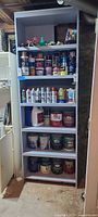 Full shelf view showing multiple shelves of paint cans and supplies