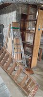 Group view showing bookshelf, aluminum ladder, wooden ladder section, plywood boards