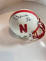 Left front view of signed mini helmet showing signature, team logo and facemask