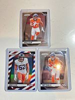 Front view of three Panini Prizm rookie cards in top loaders