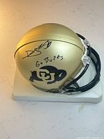 Full view of signed Colorado Buffaloes mini helmet on base