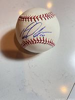 Autographed baseball showing blue ink signature on sweet spot