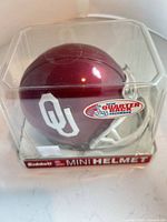 Front-side view of crimson Oklahoma Sooners mini helmet in display box