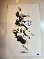 Full view of signed lithograph showing action image, signature, and hologram