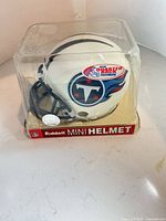 Front and side view of mini helmet in packaging showing Titans logo and Riddell branding