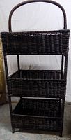 Full view of three-tier wicker shelf with handle
