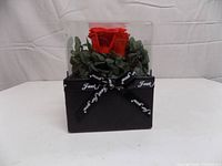 Front view of boxed red artificial rose