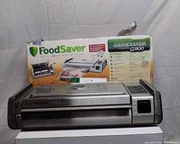Front view of FoodSaver G800 Titanium sealer resting in front of its box