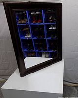 Front view showing dark brown beveled frame and intact glass