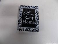 Front view of black and white plaque showing text and decorative border