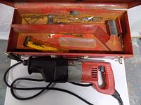 Open case showing reciprocating saw, blades, blade holders